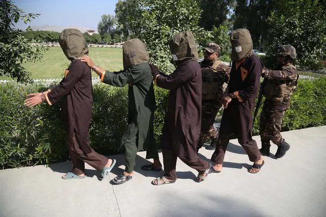 Afghan security officials show a group of suspected militants who are accused of planning attacks on government and security forces after their arrest in Jalalabad, Afghanistan, 15 October 2019. The government now controls less than 60 percent of Afghan territory amid gains for the Taliban, who governed the country for several years prior to the US invasion in October 2001. (Photo by Ghulamullah Habibi/EPA/EFE)