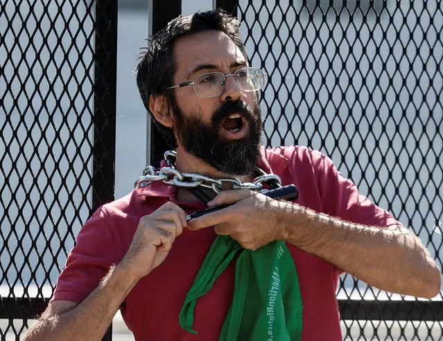 An abortion rights activist chains himself to security fencing while protesting outside the U.S. Supreme Court in Washington, U.S., June 6, 2022. (Photo by Evelyn Hockstein/Reuters)