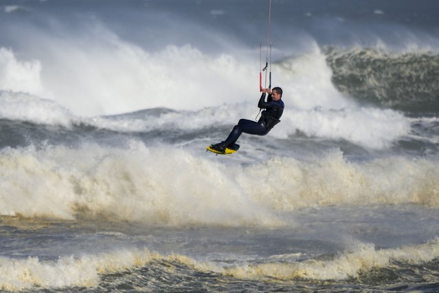 A kite surfer enjoys strong winds and surf at Birubi Point in Anna Bay, Australia, Sunday, June 12, 2022. (Photo by Mark Baker/AP Photo)