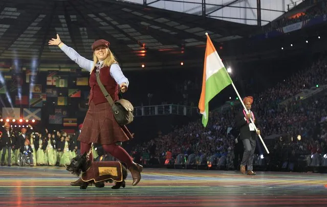 A host with a Scottish Terrier walks ahead of India's flag bearer Vijay Kumar, right, during the opening ceremony for the Commonwealth Games 2014 in Glasgow, Scotland, Wednesday July 23, 2014. (Photo by Frank Augstein/AP Photo)