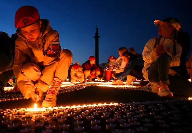 Members of patriotic movements light candles during the All-Russian action “Candle of Memory”, at Dvortsovaya Square in Saint Petersburg early on June, 22, 2022 to mark 81 years since the Nazi invasion of the Soviet Union. It has been 81 years since the German Wehrmacht launched Operation Barbarossa and the anniversary of the beginning of the Great Patriotic War of the Soviet Union against Nazi Germany in 1941. (Photo by Olga Maltseva/AFP Photo)