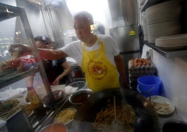 Hawker Chen Fu Yuan, 72, sells Char Kway Teow (fried noodles) in his stall at a hawker centre in Singapore May 21, 2016. (Photo by Edgar Su/Reuters)