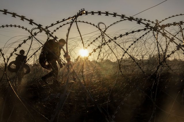 This handout photograph taken and released by the Press service of the 24th mechanized brigade named after King Danylo of the Armed Forces of Ukraine on October 30, 2024 shows engineers of the 24th mechanized brigade named after King Danylo installing razor wire along the frontline in the Donetsk region, amid the Russian invasion in Ukraine. (Photo by Press service of the 24th mechanized brigade named after King Danylo/AFP Photo)