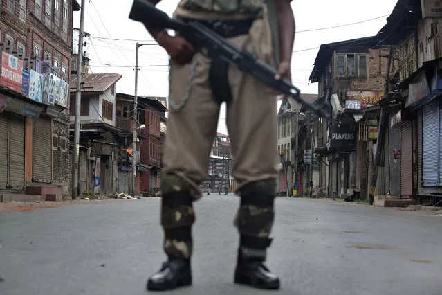 Indian paramilitary soldiers stand guard during a curfew in Srinagar, Indian controlled Kashmir, Friday, July 15, 2016. Curfew imposed in the disputed Himalayan region continued for the seventh straight day to check anti-India violence following the recent killing of  a charismatic Kashmiri insurgent Burhan Wani. (Photo by Dar Yasin/AP Photo)