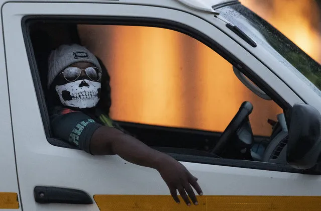 A minibus taxi driver wearing a face musk looks on during his journey in Kwa-Thema east of Johannesburg, South Africa, Tuesday, March 17, 2020. President Cyril Ramaphosa said all schools will be closed for 30 days from Wednesday and he banned all public gatherings of more than 100 people. South Africa will close 35 of its 53 land borders and will intensify screening at its international airports. (Photo by Themba Hadebe/AP Photo)