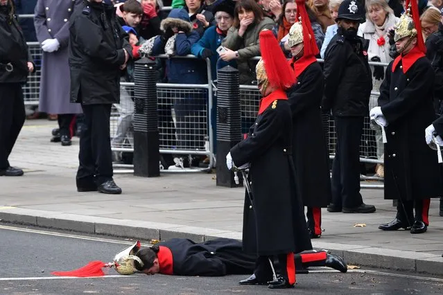 A member of the Household Cavalry lies on the ground ahead of the Remembrance Sunday ceremony at the Cenotaph on Whitehall in central London, Britain on November 14, 2021. (Photo by Justin Tallis/Pool via Reuters)