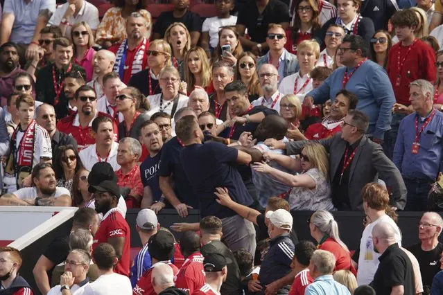 Fans fight on the tribune during the English Premier League soccer match between Manchester United and Brighton at Old Trafford stadium in Manchester, England, Sunday, August 7, 2022. (Photo by Dave Thompson/AP Photo)