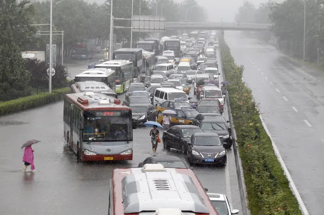 Vehicles are trapped on a flooded street during a heavy rainfall in Beijing, China, July 20, 2016. (Photo by Reuters/China Daily)