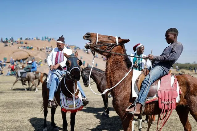 Boys ride on horses past the koppies where people are gathering in Marikana on August 16, 2022, ahead of the 10th anniversary of the Marikana massacre. August 16, 2022 marks 10 years since 34 mineworkers were killed and over 70 others injured when South African Police Services (SAPS) opened fire on workers who were protesting over wages at the then LONMIN-owned Marikana platinum mine. An official inquiry blamed the deaths and injuries squarely on police, recommending that those responsible be investigated and prosecuted. For anguished survivors and victims' families, the memories are still agonisingly fresh. (Photo by Phill Magakoe/AFP Photo)