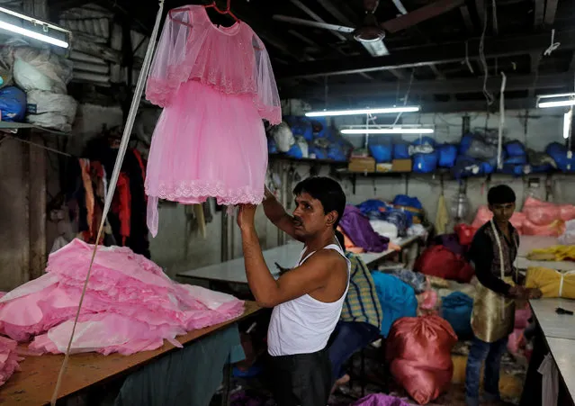 A worker conducts a final check on a dress inside a small-scale garment manufacturing unit in Mumbai, India, August 1, 2016. (Photo by Danish Siddiqui/Reuters)