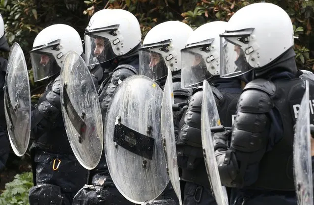 Belgian riot police officers shelter behind their shields while demonstrators throw eggs as farmers and dairy farmers from all over Europe take part in a demonstration outside an European Union farm ministers emergency meeting at the EU Council headquarters in Brussels, Belgium, September 7, 2015. (Photo by Jacky Naegelen/Reuters)