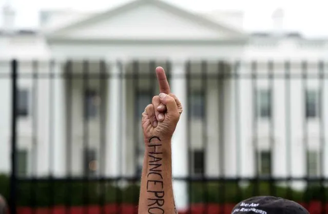 A protestor holds up a middle finger to the White House in Washington, DC, September 9, 2014. (Photo by Saul Loeb/AFP Photo)