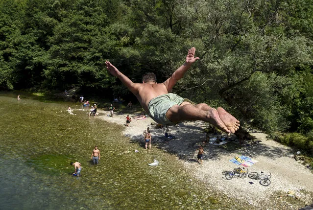 A young man dives in the river Treska near Skopje on August 8, 2019 as temperatures reached 37 degrees celsius. (Photo by Robert Atanasovski/AFP Photo)