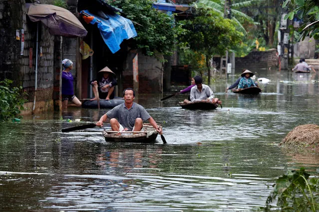 Residents paddle boats, in a flooded village, after heavy rain, caused by a tropical depression in Hanoi, Vietnam October 17, 2017. (Photo by Reuters/Kham)