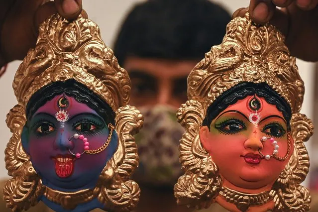 A shopkeeper displays idols representing deities and characters from the Hindu mythology used as a decoration ahead of the Navaratri (nine nights) festival, in Chennai on September 20, 2021. (Photo by Arun Sankar/AFP Photo)