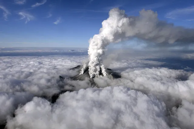 Dense white plumes rise high in the air as Mt. Ontake erupts in central Japan, Saturday, September 27, 2014. (Photo by AP Photo/Kyodo News)
