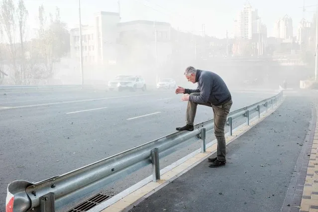 A man reacts surrounded by dust near the site of a drone attack in Kyiv on October 17, 2022, amid the Russian invasion of Ukraine. (Photo by Yasuyoshi Chiba/AFP Photo)