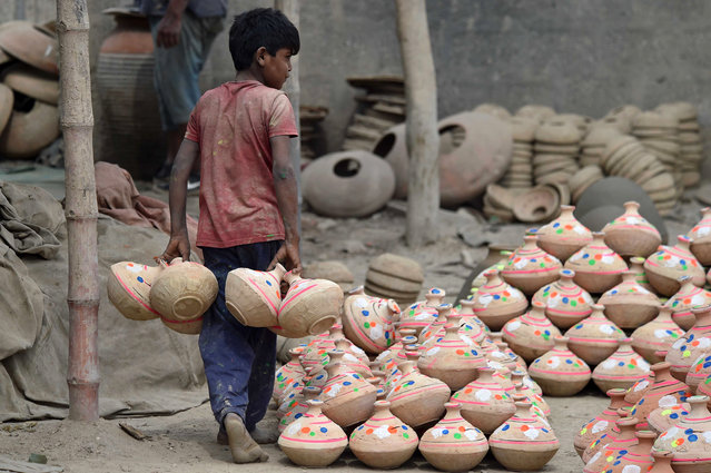 A young laborer works at a clay pottery workshop on the outskirts of Karachi, Pakistan, 25 February 2025. The traditional clay pot is gaining popularity in Pakistan due to its all-natural benefits and affordable prices. Hand-made clay pottery is widely used as household goods in the country. (Photo by Shahzaib Akber/EPA/EFE)