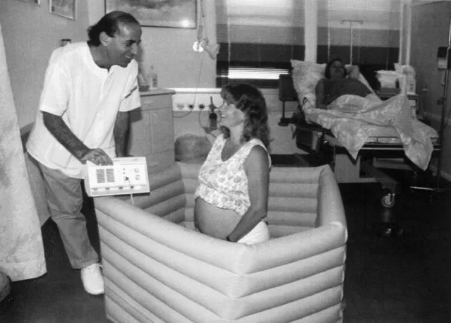 An unidentified British expectant mother tries out a water filled pool while an obstetrician watches over her with a birth monitoring device at a maternity ward at Yosef Tal Hospital in Eilat, Israel, September 16, 1992. Six British women came to Eilat to give birth among dolphins in the Red Sea but the Israeli Health Ministry did not permit it. The women will be giving birth in plastic pools of water instead. (Photo by Reuven Zaltz/AP Photo)