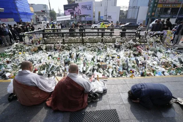 Buddhist monks pray for victims of a deadly accident following Saturday night's Halloween festivities on a street near the scene in Seoul, South Korea, Tuesday, November 1, 2022. (Photo by Ahn Young-joon/AP Photo)