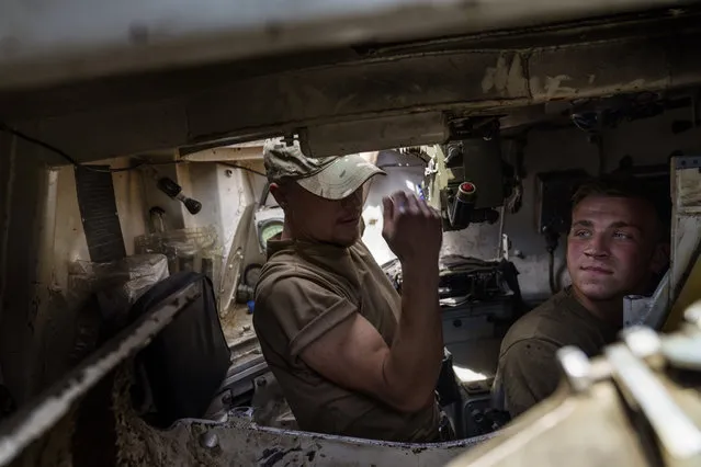 Ukrainian servicemen sit inside their tank while taking a break during training with their unit in the Donetsk region, eastern Ukraine, Monday,  August 22, 2022. (Photo by David Goldman/AP Photo)