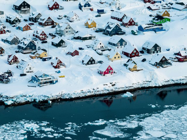 Houses covered by snow are seen on the coast of a sea inlet of Nuuk, Greenland, Friday, March 7, 2025. (Photo by Evgeniy Maloletka/AP Photo)