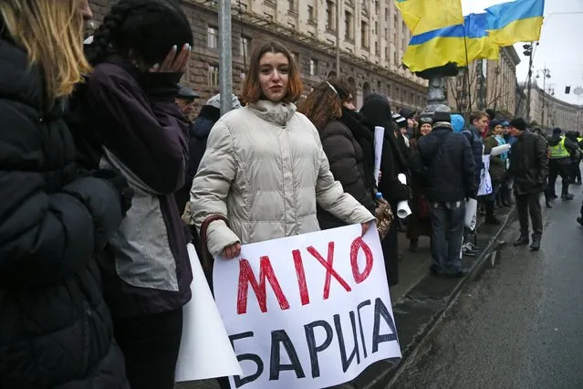 A woman hols a poster reads 'Mikho (Mikheil Saakashvili) is a thief!' as supporters of former Georgian President Mikheil Saakashvili march in protest of corruption in Ukraine in Kiev, Ukraine, Sunday, December 10, 2017. (Photo by Efrem Lukatsky/AP Photo)