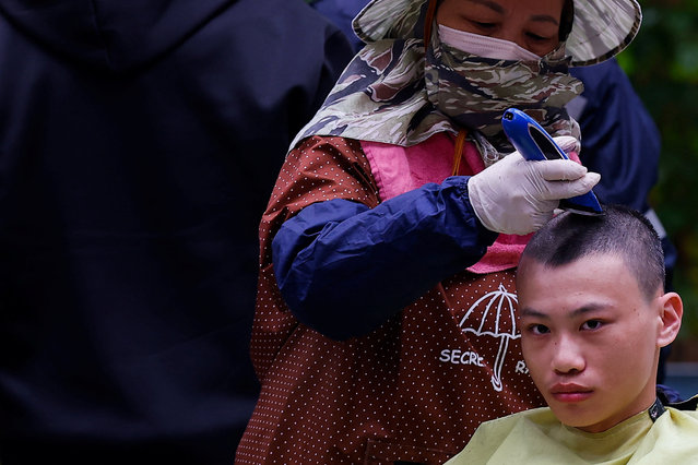 A member of the first batch of new recruits has his hair shaved as he set to begin one-year compulsory military service in Taiwan, after the previous four-month conscription period was extended starting 2024, in Taichung, Taiwan on January 25, 2024. (Photo by Ann Wang/Reuters)