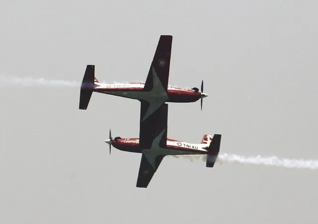 Two Wong Bee airplanes from the Jupiter Aerobatic Team of the Indonesian Air Force fly past each other during a rehearsal for the ceremony marking the 70th anniversary of Indonesia's military in Cilegon, Banten province, October 3, 2015. Indonesia will celebrate the anniversay of its military on October 5. (Photo by Reuters/Beawiharta)