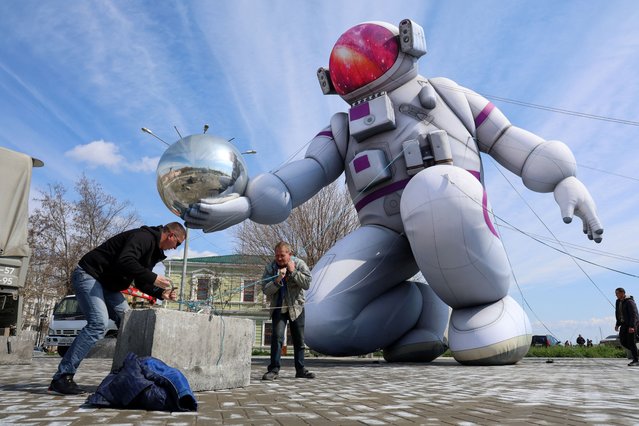 Workers secure the ropes of a giant inflatable in the shape of a cosmonaut installed ahead of Cosmonautics Day, which is widely celebrated in Russia on April 12 to mark the anniversary of Yuri Gagarin's historic first human space flight in 1961, in a square in the Black Sea port city of Yevpatoriya, Crimea, on April 9, 2025. (Photo by Alexey Pavlishak/Reuters)