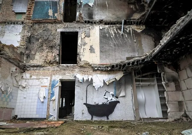 A new graffiti in Banksy's signature style, although not posted by the mercurial artist on social media, is seen on the wall of a destroyed building in the Ukrainian village of Horenka, which had been occupied by Russia until April and heavily damaged by fighting in the early days of Russian invasion on November 13, 2022. (Photo by Gleb Garanich/Reuters)
