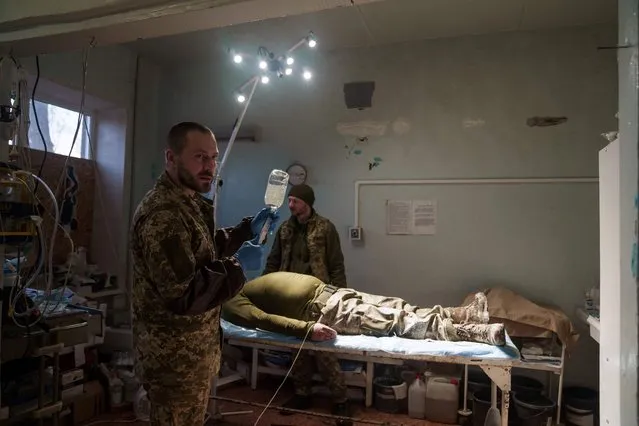 A military doctor operates on a slightly wounded Ukrainian soldier in a stabilisation hospital near the front line in Donetsk region on 17, 2023. (Photo by Ihor Tkachov/AFP Photo)