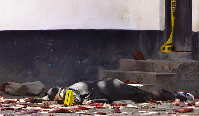 In this file photo dated Sunday September 11, 2016, one of the bodies of three women who were shot dead by police, outside the central police station in the coastal city of Mombasa, Kenya. Human rights activists with the Muslims for Human Rights group, on Friday Sept. 23, 2016, accused Kenyan police of executing three women who allegedly attacked a police station this month after pledging allegiance to the Islamic State group. (Photo by AP Photo)