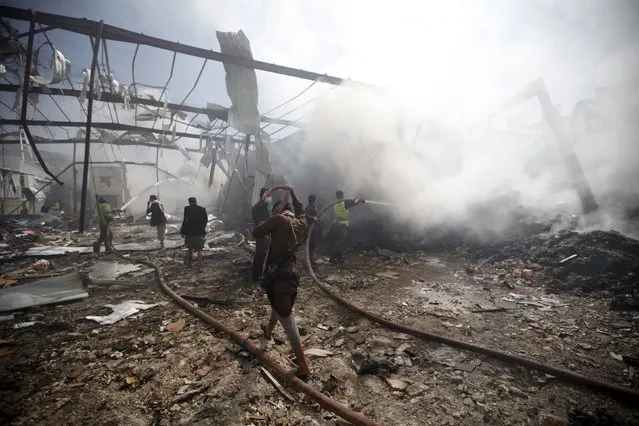 Firefighters extinguish a fire at a food storage warehouse hit by a Saudi-led air strike in Yemen's capital Sanaa October 25, 2015. (Photo by Khaled Abdullah/Reuters)