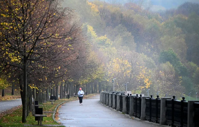 A woman runs along an embankment of the Moskva river in Moscow on October 16, 2020. (Photo by Alexander Nemenov/AFP Photo)