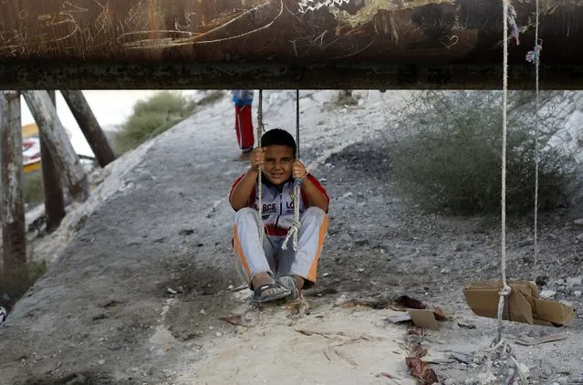 A boy plays under a pipe in the fishermen's village in the El Max area of the Mediterranean city of Alexandria October 18, 2014. (Photo by Amr Abdallah Dalsh/Reuters)
