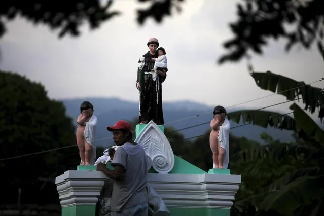 A man decorates a grave during All Saints day in Nahuizalco on November 1, 2015. People visit the cemeteries and graves of deceased relatives and friends to commemorate All Saints Day, which falls on November 1. (Photo by Jose Cabezas/Reuters)