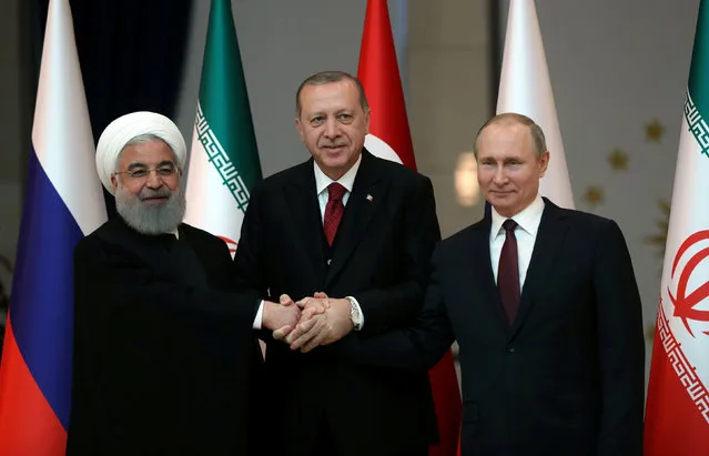 Presidents Hassan Rouhani of Iran, Tayyip Erdogan of Turkey and Vladimir Putin of Russia pose before their meeting in Ankara, Turkey April 4, 2018. (Photo by Tolga Bozoglu/Pool via Reuters)