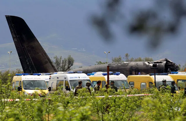 An Algerian military plane is seen after crashing near an airport outside the capital Algiers, Algeria April 11, 2018. Over 250 people are reported killed when the military plane crashed soon after takeoff in a farm field in northern Algeria on Wednesday, officials said. (Photo by Ramzi Boudina/Reuters)