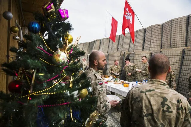 U.S. soldiers from the 3rd Cavalry Regiment take part in a Christmas Eve celebration with soldiers from the Polish army's 21st Mountain Brigade on forward operating base Gamberi in the Laghman province of Afghanistan December 24, 2014. (Photo by Lucas Jackson/Reuters)