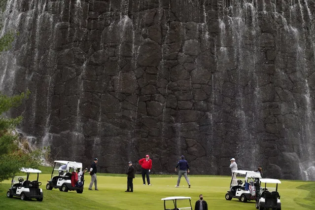 President Donald Trump, center, plays golf at Trump National Golf Club, Friday, November 27, 2020, in Sterling, Va. (Photo by Alex Brandon/AP Photo)