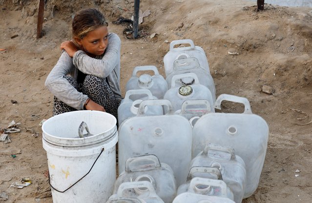 A displaced Palestinian girl waits to collect water after Hamas agreed to release hostages and accept some other terms in a U.S. plan to end the war, in the central Gaza Strip on October 4, 2025. (Photo by Mahmoud Issa/Reuters)