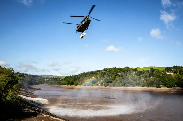 Operations & Exercises, highly commended. A Chinook Mk6a approaches low over the water towards Whaley dam with an underslung load of sandbags to drop. RAF Odiham Chinook Force helped spread sandbags over the dam wall in Whaley Bridge after around 400 tonnes of aggregate were brought in to plug the dam and divert water away from the town. (Photo by Cpl Rob Travis/2020 RAF Photo Competition)