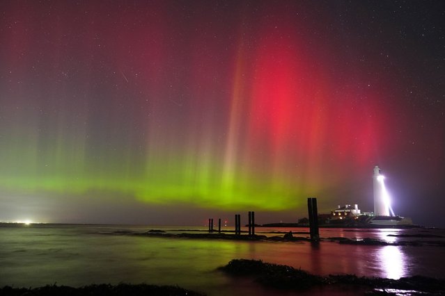 The sky is filled with colour from the aurora borealis, also known as the Northern Lights, at St Mary's lighthouse in Whitley Bay on the North East coast of England on Wednesday, March 26, 2025. (Photo by Owen Humphreys/PA Images via Getty Images)