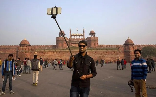 An Indian tourist uses a selfie stick to take a photograph in front of the historical Red Fort monument in New Delhi, India, Tuesday, January 6, 2015. (Photo by Manish Swarup/AP Photo)