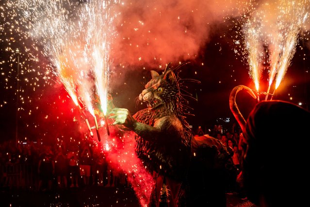 A hellish beast explodes pyrotechnics by the streets during the celebration of a correfoc on occasion of Poble Sec quarter summer festival in Barcelona on July 27, 2024. Correfocs are an old Catalan tradition where people dress as devils and light firecrackers and flares. (Photo by /EPA/EFE/Rex Features/Shutterstock)