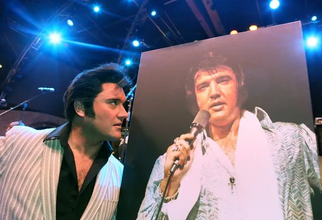 Artist Grahame Patrick from Ireland stands next to a photo of late US singer Elvis Presley during a rehearsal of the musical “Elvis – The Musical” in Berlin, Germany, 06 January 2015 (issued 07 January). Patrick is performing as an Elvis look-alike. Presley would have turned 80 on 08 January 2015. He died on 16 August 1977 in Memphis. (Photo by Stephanie Pilick/EPA)