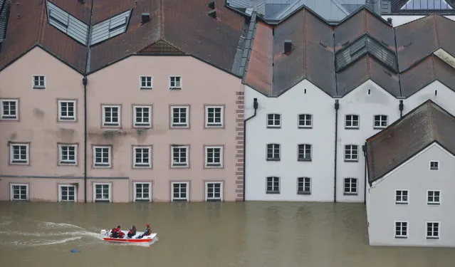 Members of the Red Cross make their way by boats in the flooded street in the center of Passau, southern Germany, Monday, June 3, 2013. Raging waters from three rivers have flooded large parts of the southeast German city following days of heavy rainfall in central Europe. A spokesman for the city's crisis center said Monday that the situation was “extremely dramatic” and waters are expected to rise further by midday to their level highest in 70 years. (Photo by Matthias Schrader/AP Photo)