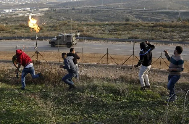 A Palestinian protester throws a Molotov cocktail towards Israeli border police jeep during clashes near Israel's Ofer Prison near the West Bank city of Ramallah November 27, 2015. (Photo by Mohamad Torokman/Reuters)