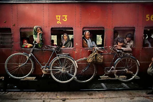 Bicycles hanging from the side of a train, West Bengal, 1983. (Photo by Steve McCurry)